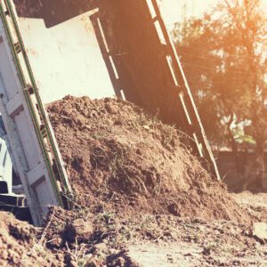 dump truck preparing ground for landscape improvement at property
